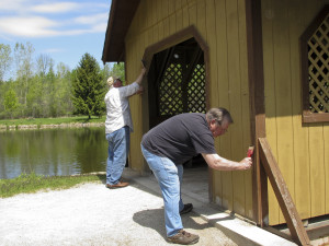 Jack Koivisto and Paul Mongin scraping paint off covered bridge