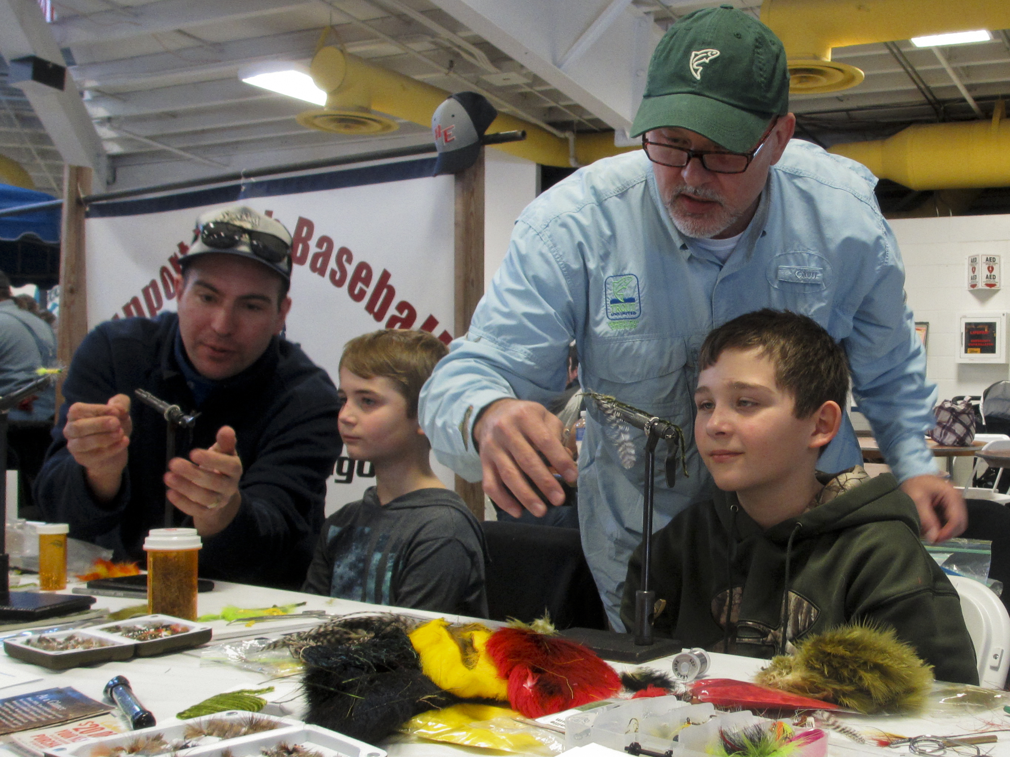 Adrian Meseberg and Mike Renish tying flies with youth at Sunnyview Expo Center outside Oshkosh